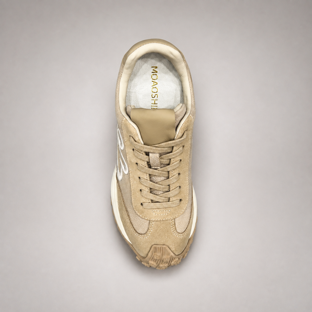 Beige sneaker top view showing a panelled lace-up upper