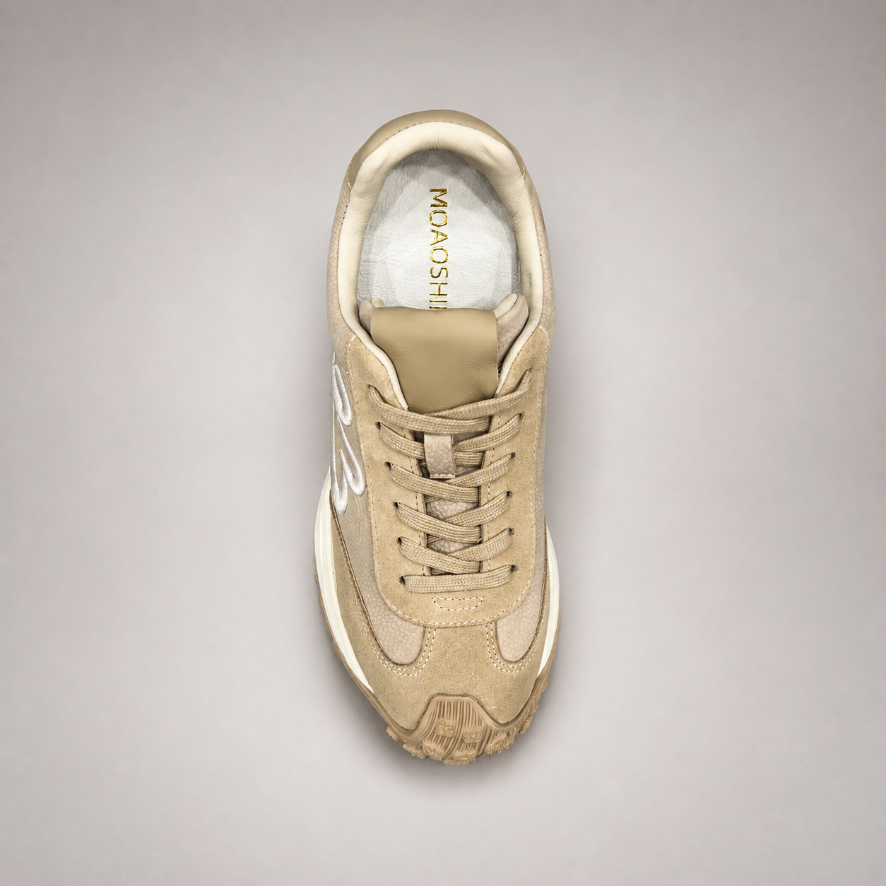 Beige sneaker top view showing a panelled lace-up upper