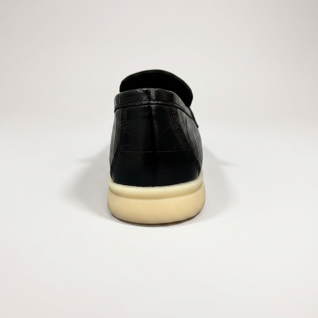 Black loafer rear view showing an eel-pattern embossed vamp and tassel detail