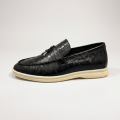 Black loafer outer side profile showing an eel-pattern embossed vamp and tassel detail