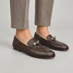 Dark brown washed leather horsebit loafers worn on foot