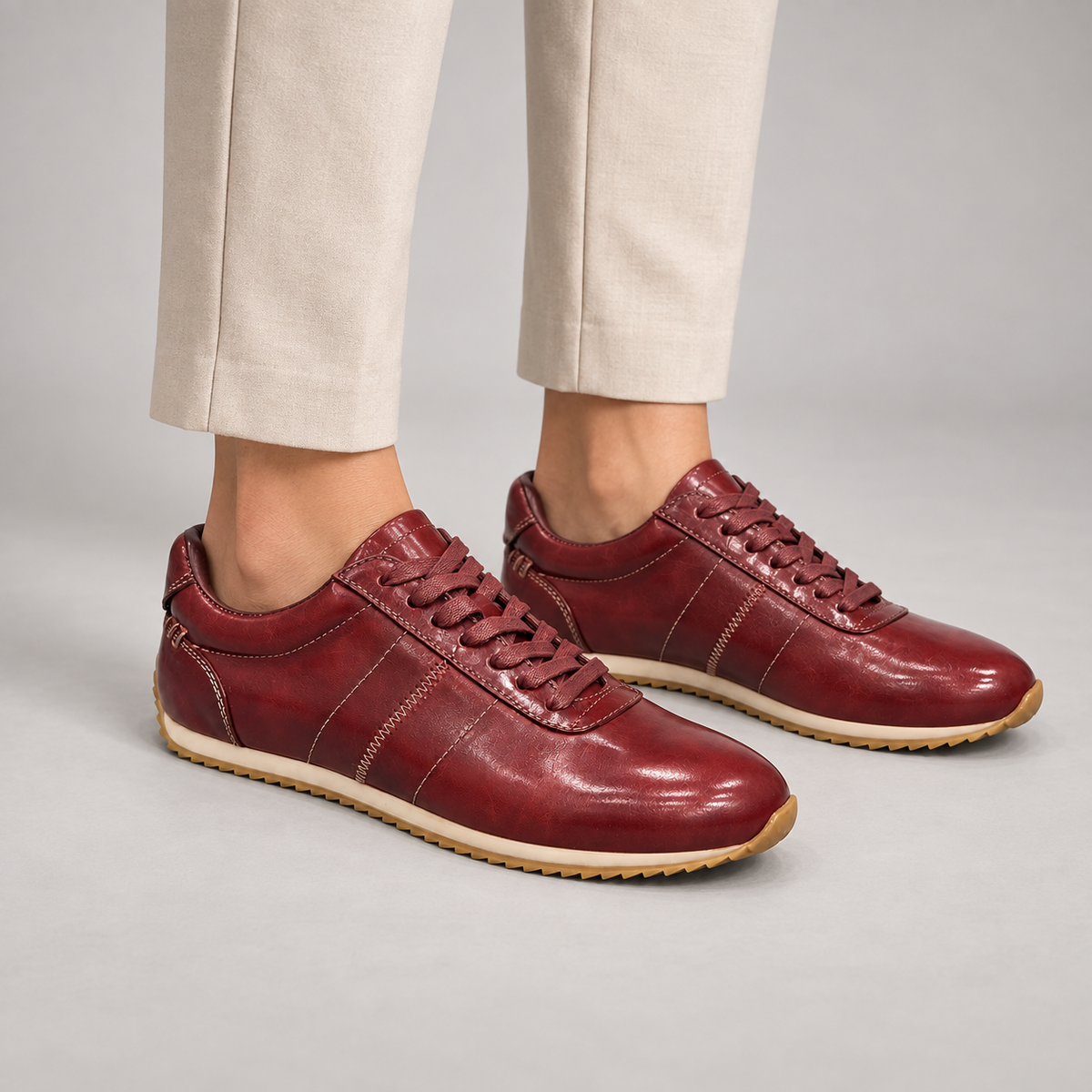 Burgundy low-top lace-up sneaker worn on foot