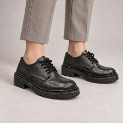 Black washed leather platform derby shoes worn on foot