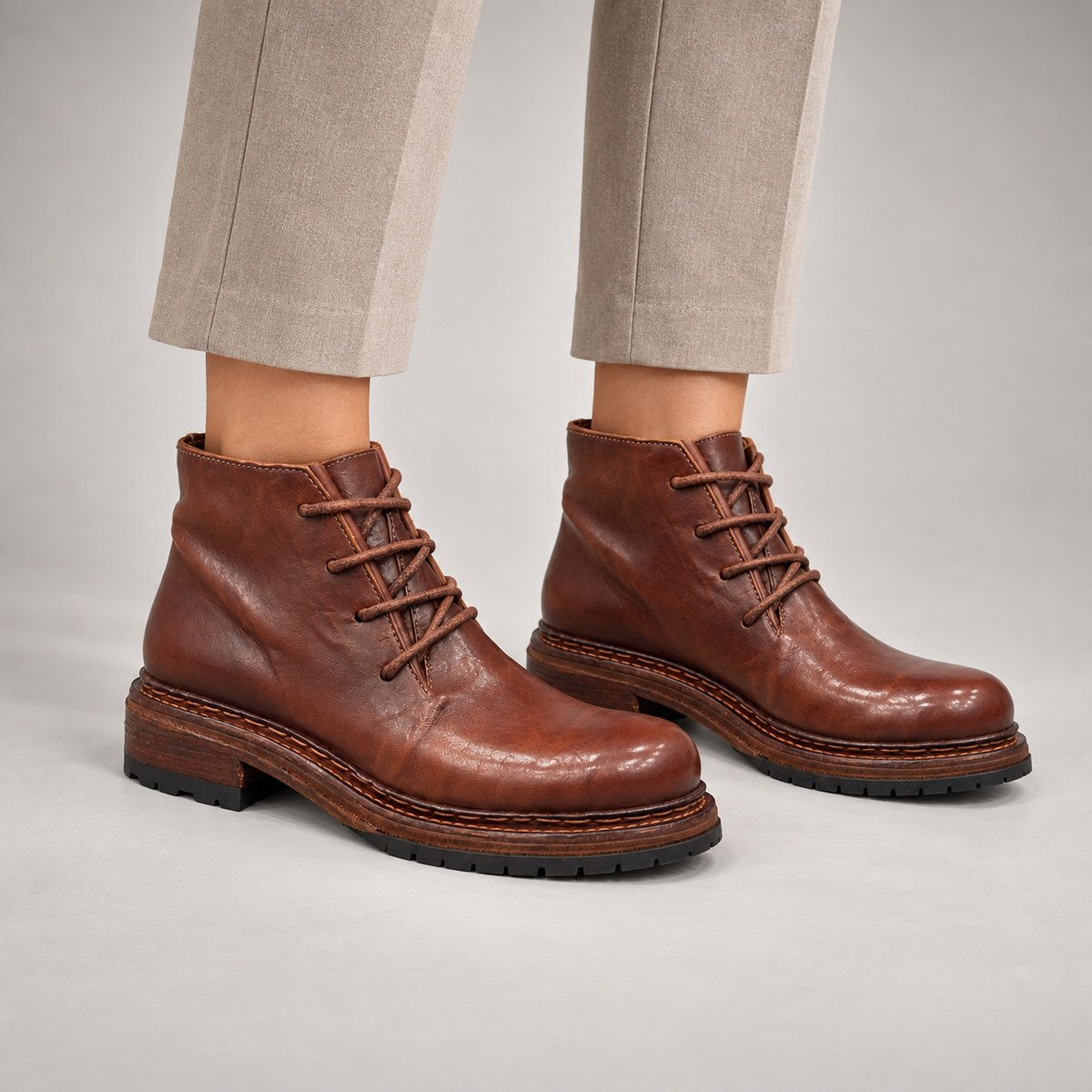 Brown washed leather lace-up ankle boots worn on foot