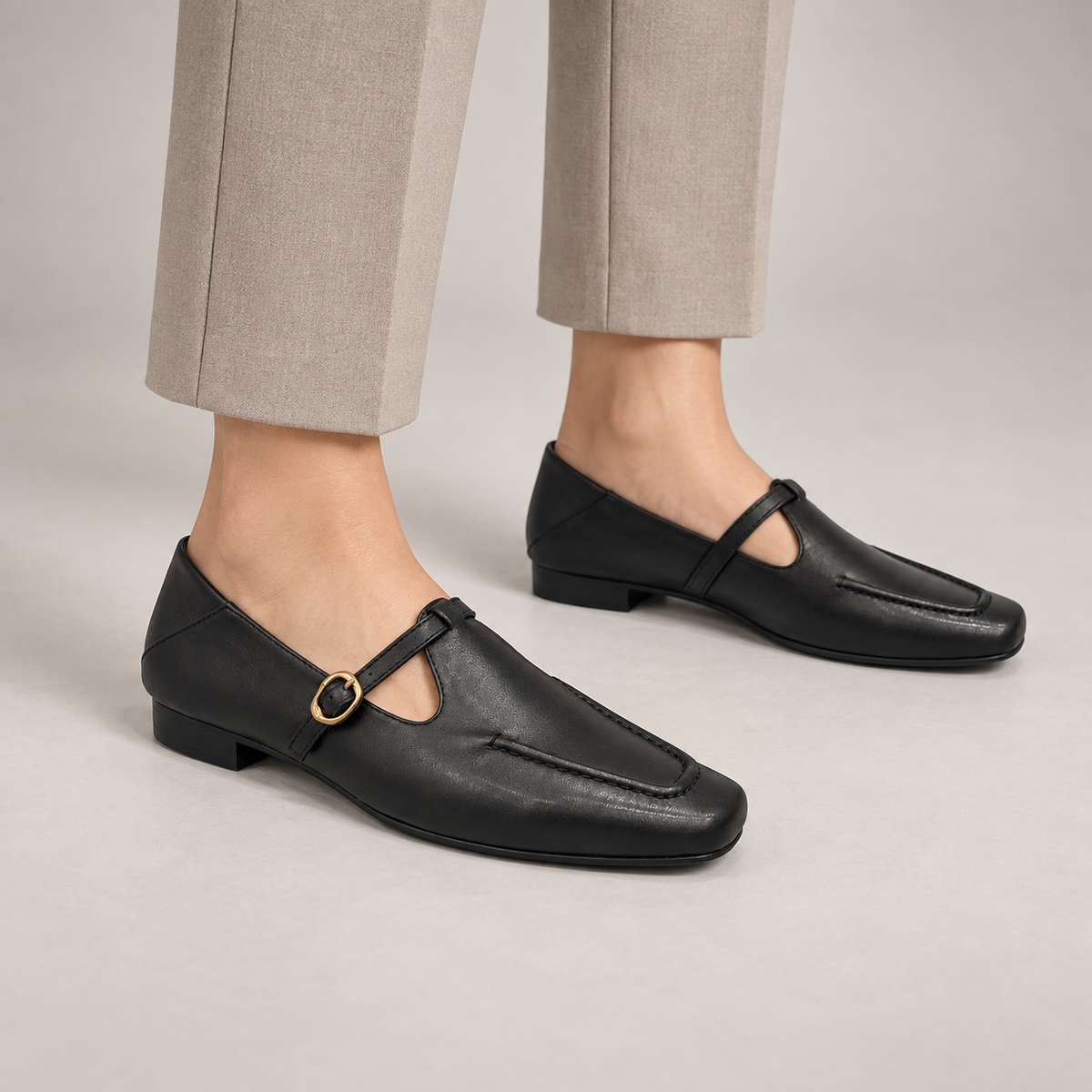 Black leather buckle-strap shoes worn on foot
