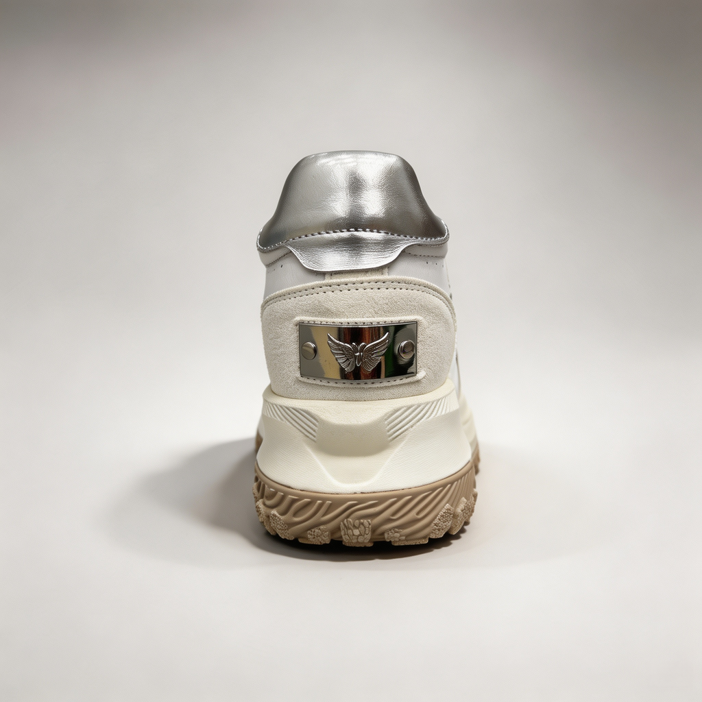 Silver sneaker rear view showing a panelled lace-up upper
