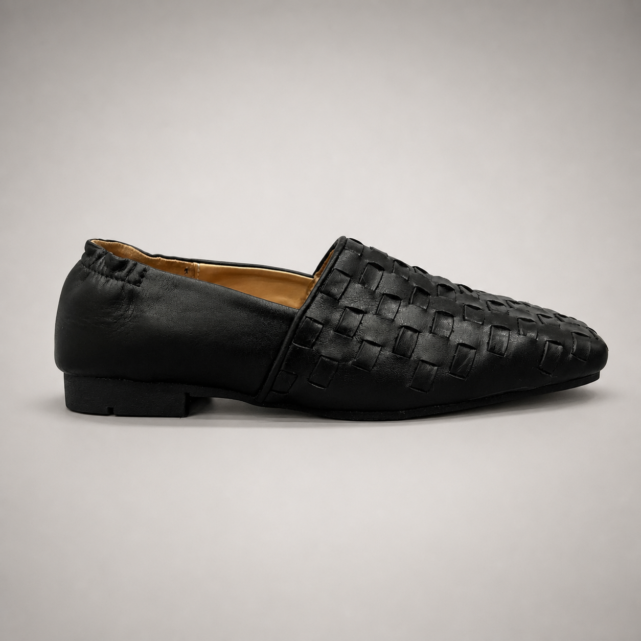 Black woven loafer side profile showing a woven slip-on upper