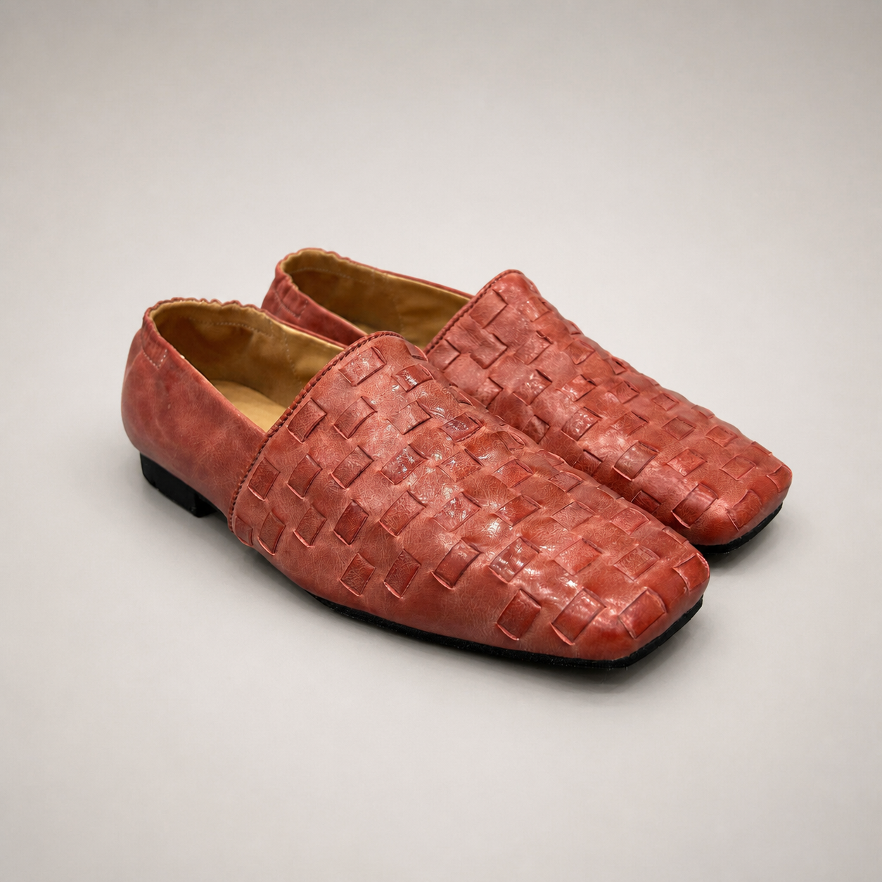 Rust woven loafer pair three-quarter view showing a woven slip-on upper