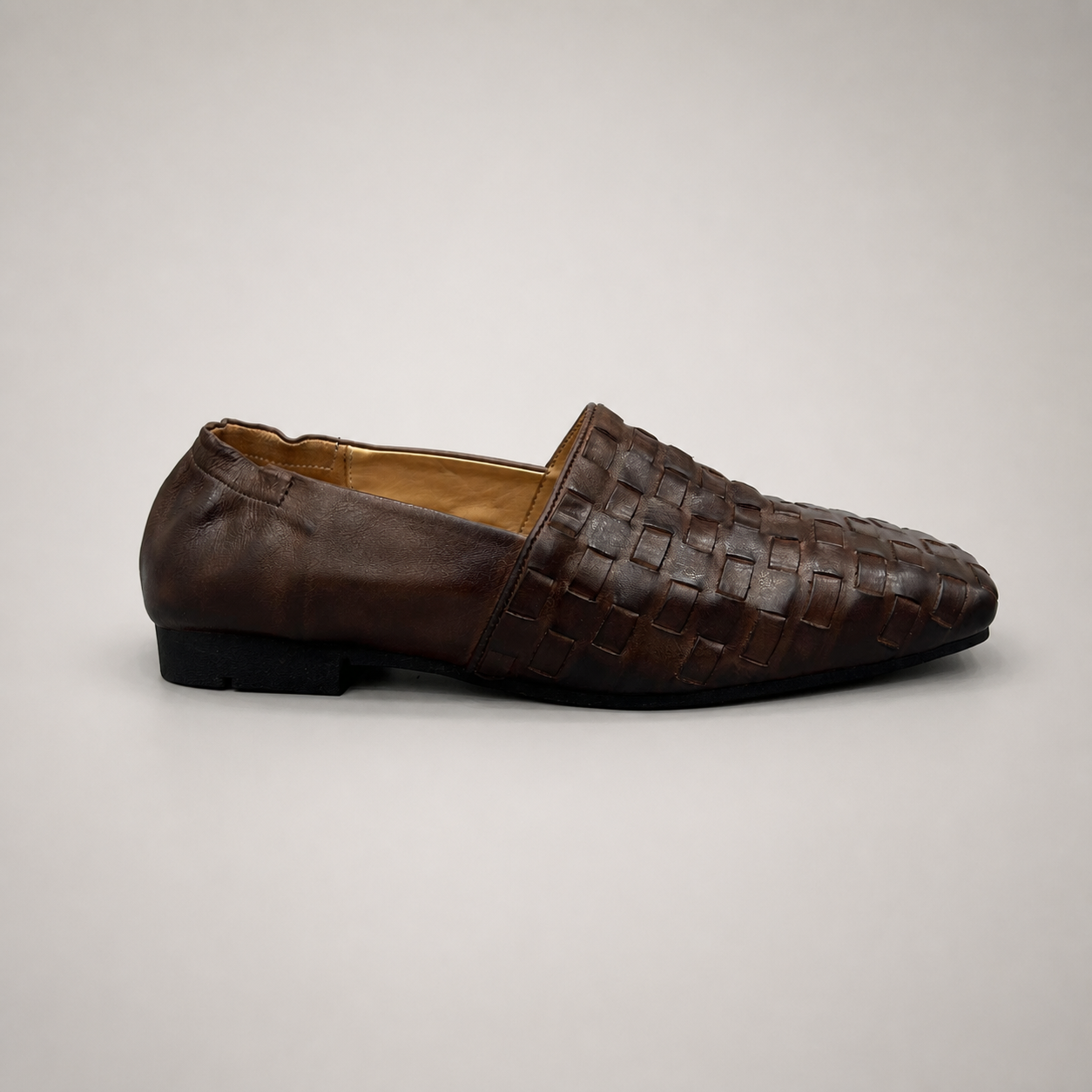 Brown woven loafer side profile showing a woven slip-on upper