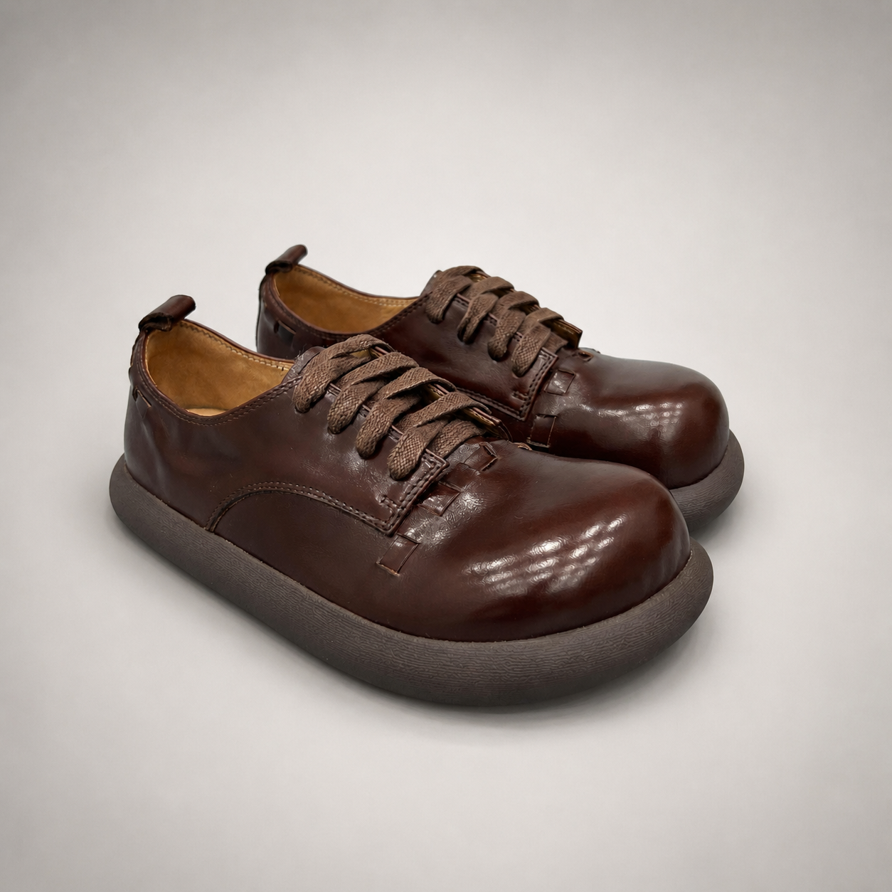 Brown lace-up shoe pair three-quarter view showing a lace-up construction