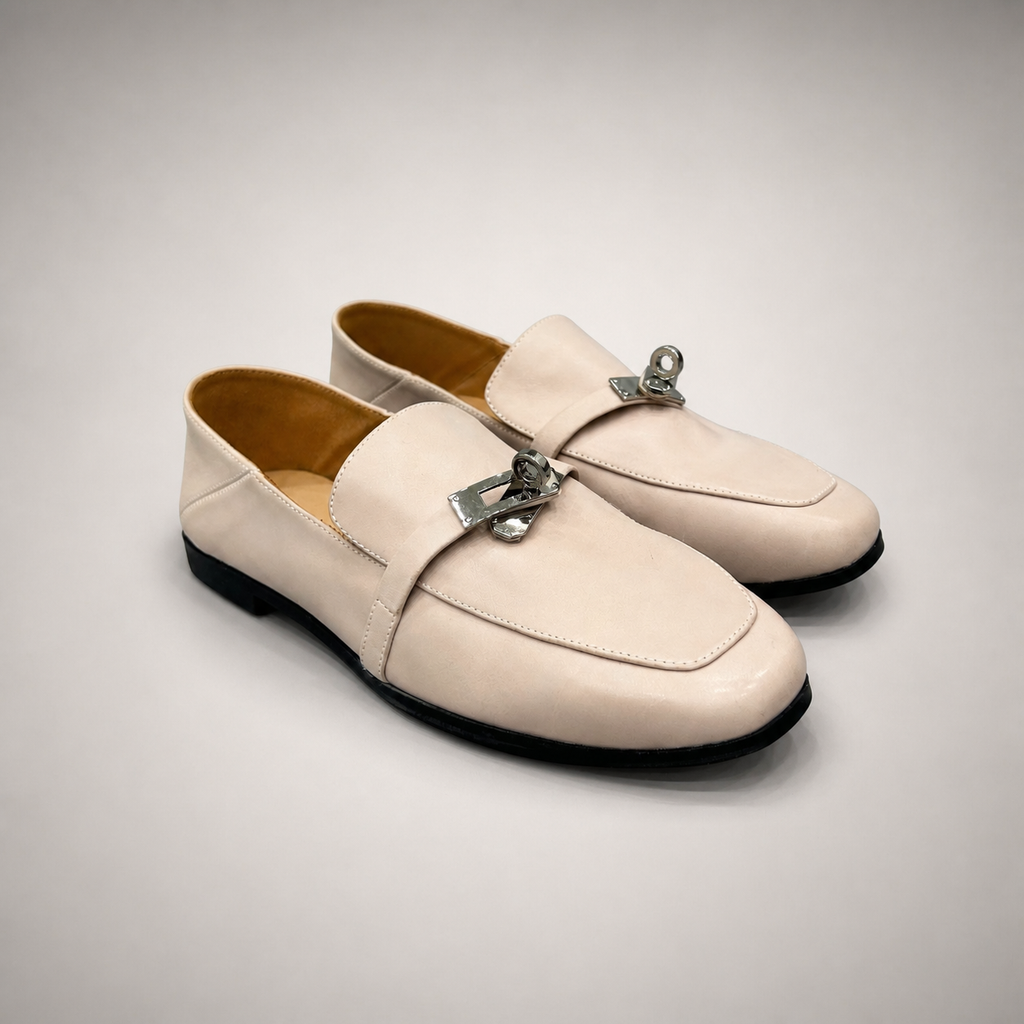 Ivory loafer pair three-quarter view showing a metal accent across the vamp