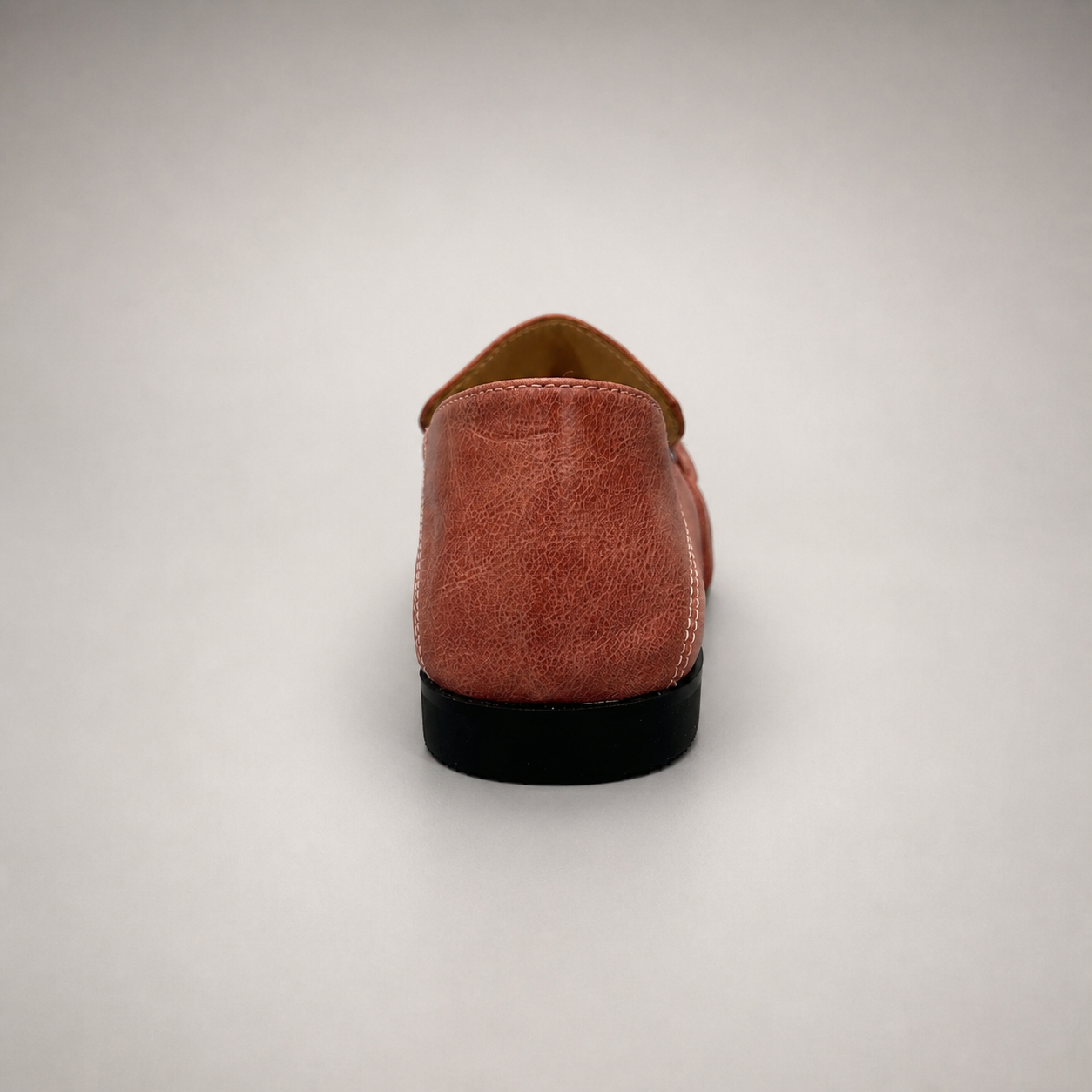 Rust loafer rear view showing a metal accent across the vamp