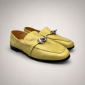 Yellow loafer pair three-quarter view showing a metal accent across the vamp