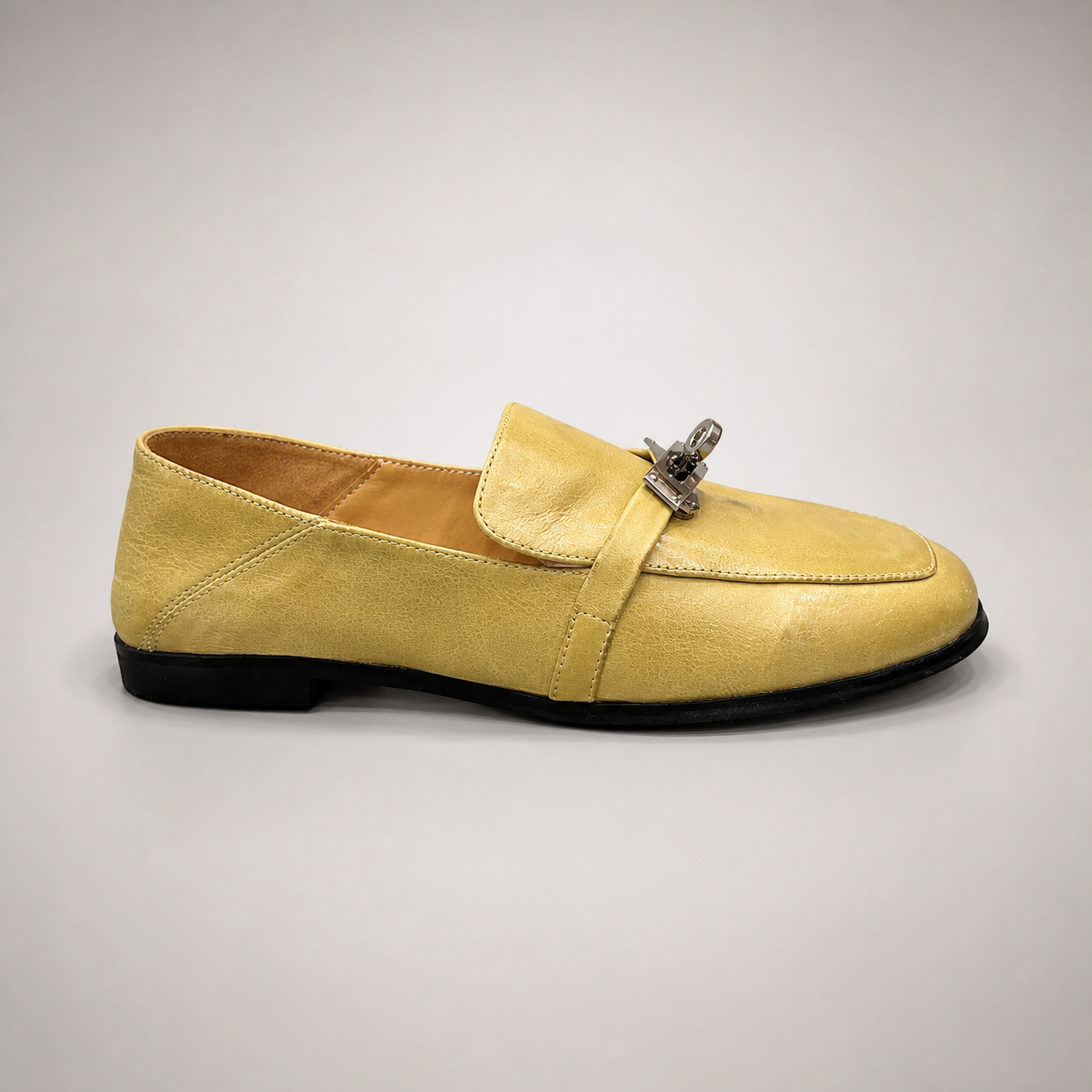 Yellow loafer side profile showing a metal accent across the vamp