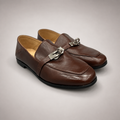 Brown loafer pair three-quarter view showing a metal accent across the vamp