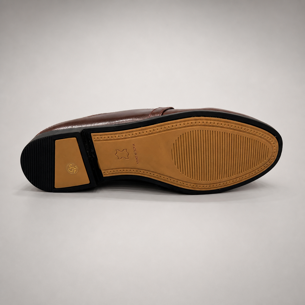 Brown loafer rear view showing a metal accent across the vamp