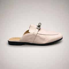 Ivory mule loafer side profile showing an open-back mule construction and metal vamp accent