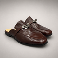 Brown mule loafer pair three-quarter view showing an open-back mule construction and metal vamp accent