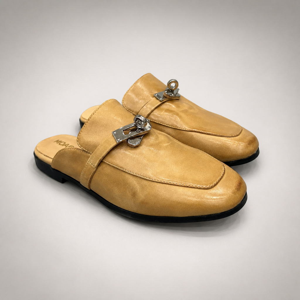 Tan mule loafer pair three-quarter view showing an open-back mule construction and metal vamp accent