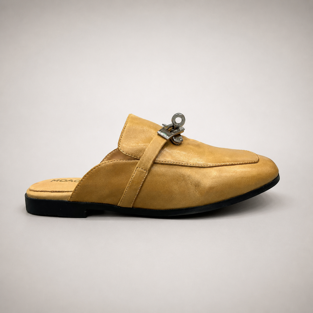 Tan mule loafer side profile showing an open-back mule construction and metal vamp accent