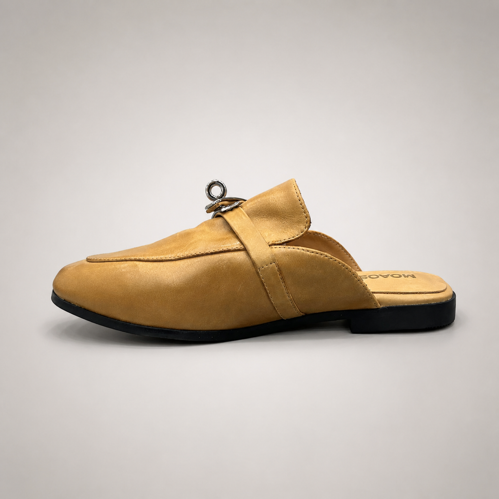 Tan mule loafer opposite side profile showing an open-back mule construction and metal vamp accent