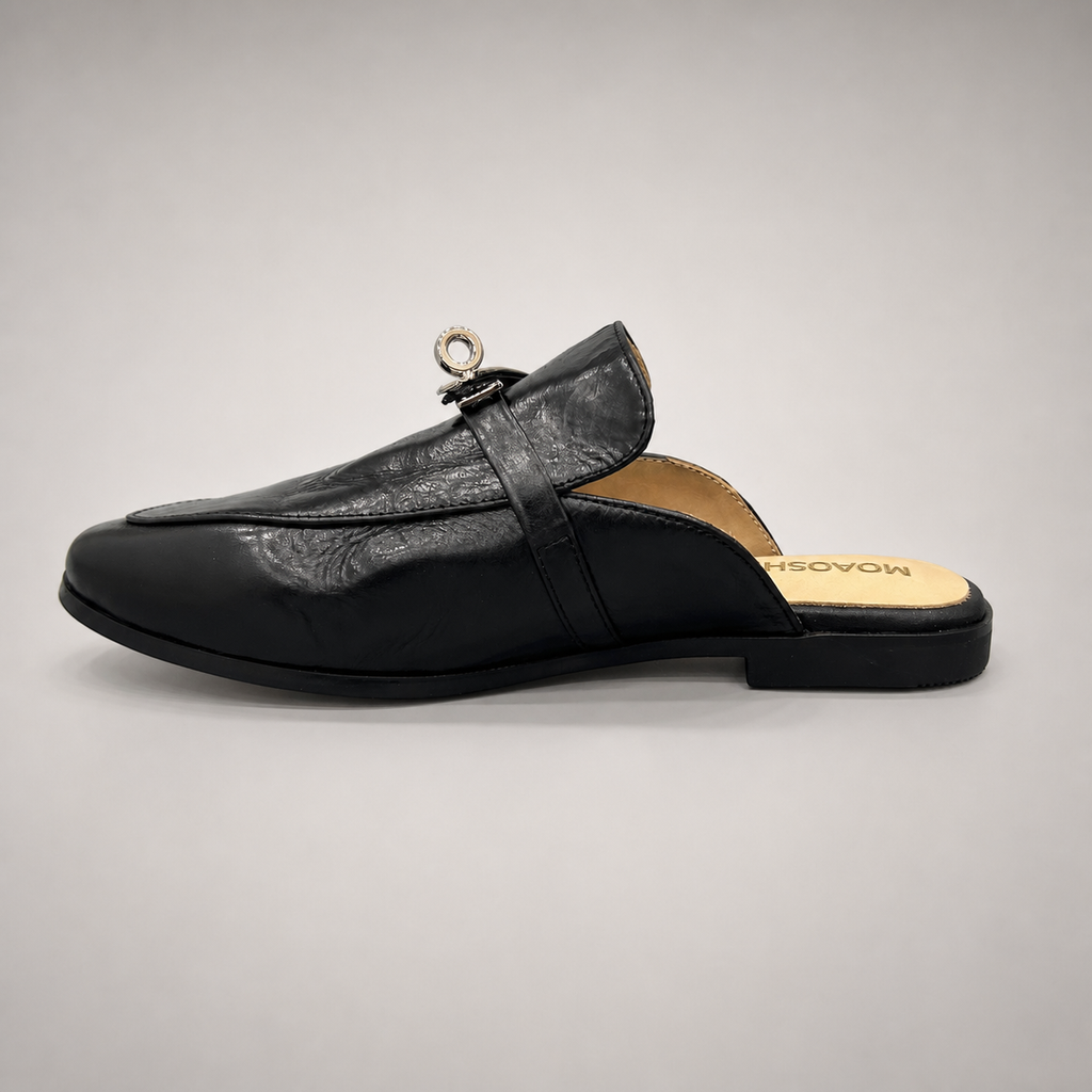Black mule loafer opposite side profile showing an open-back mule construction and metal vamp accent