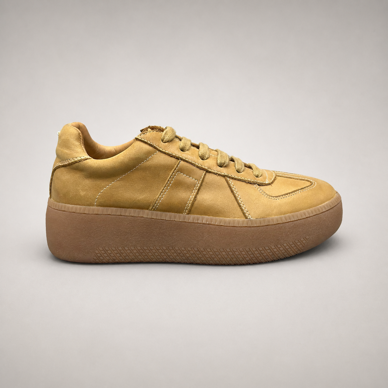 Tan platform sneaker side profile showing a lace-up upper and raised platform sole