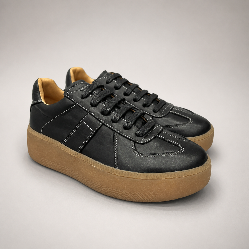 Black platform sneaker pair three-quarter view showing a lace-up upper and raised platform sole