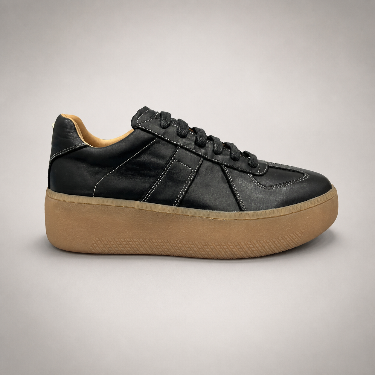 Black platform sneaker side profile showing a lace-up upper and raised platform sole