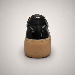 Black platform sneaker rear view showing a lace-up upper and raised platform sole