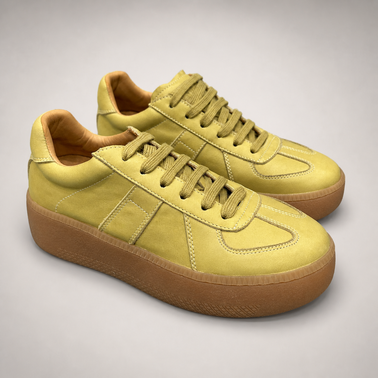 Yellow platform sneaker pair three-quarter view showing a lace-up upper and raised platform sole