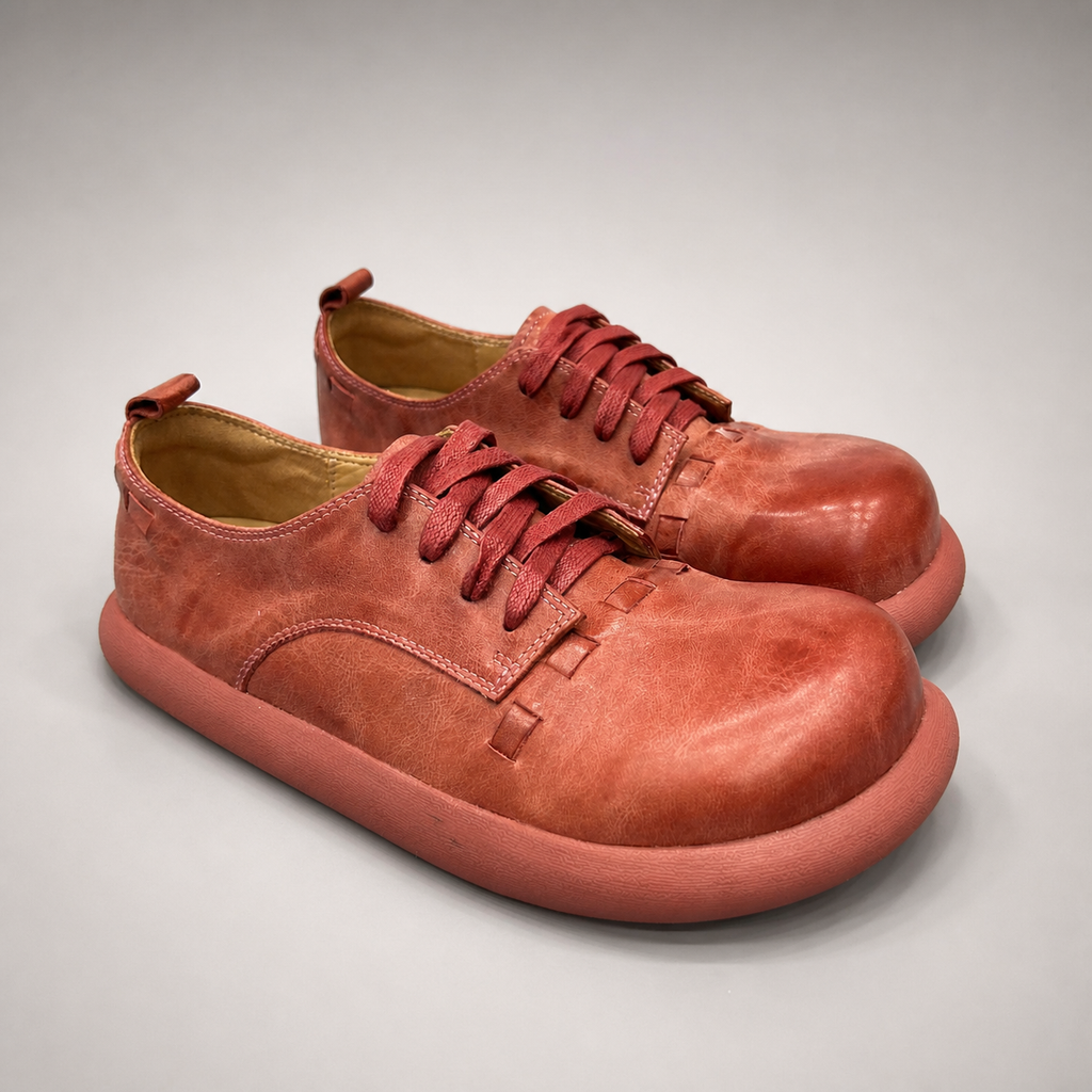 Rust low-top sneaker pair three-quarter view showing a lace-up low-top construction