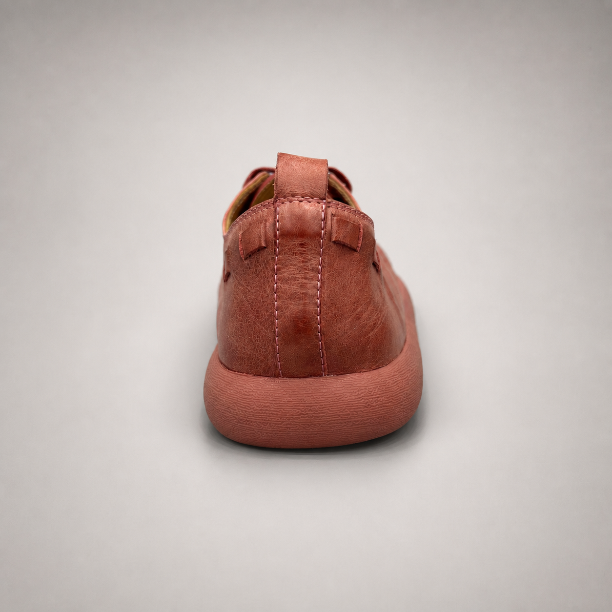 Rust low-top sneaker rear view showing a lace-up low-top construction