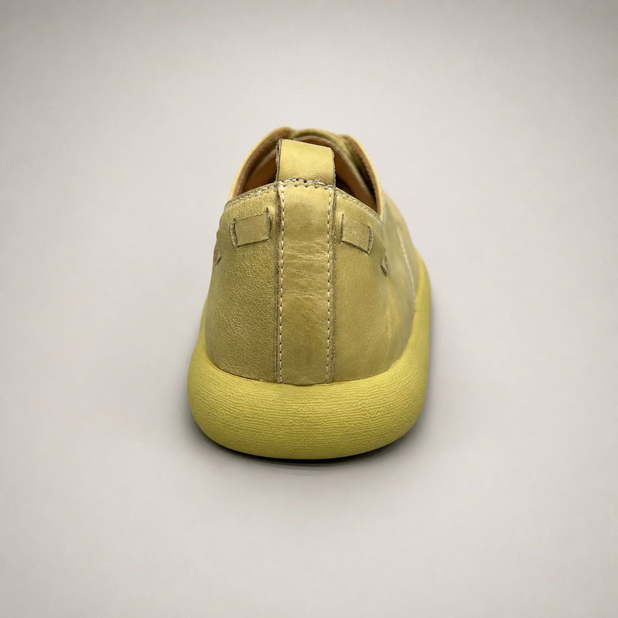 Yellow low-top sneaker rear view showing a lace-up low-top construction