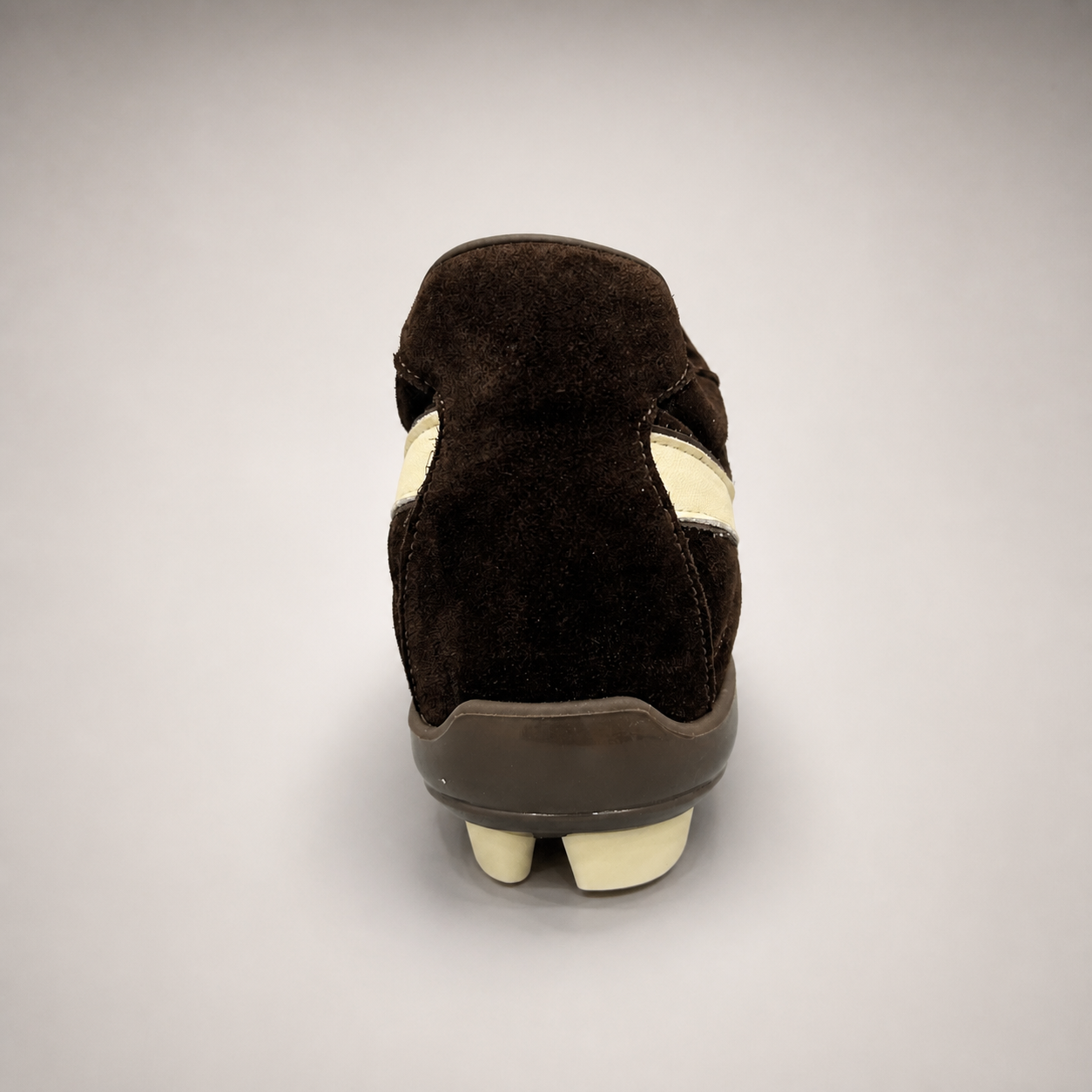 Dark Brown soccer shoe rear view showing a lace-up upper and molded outsole studs