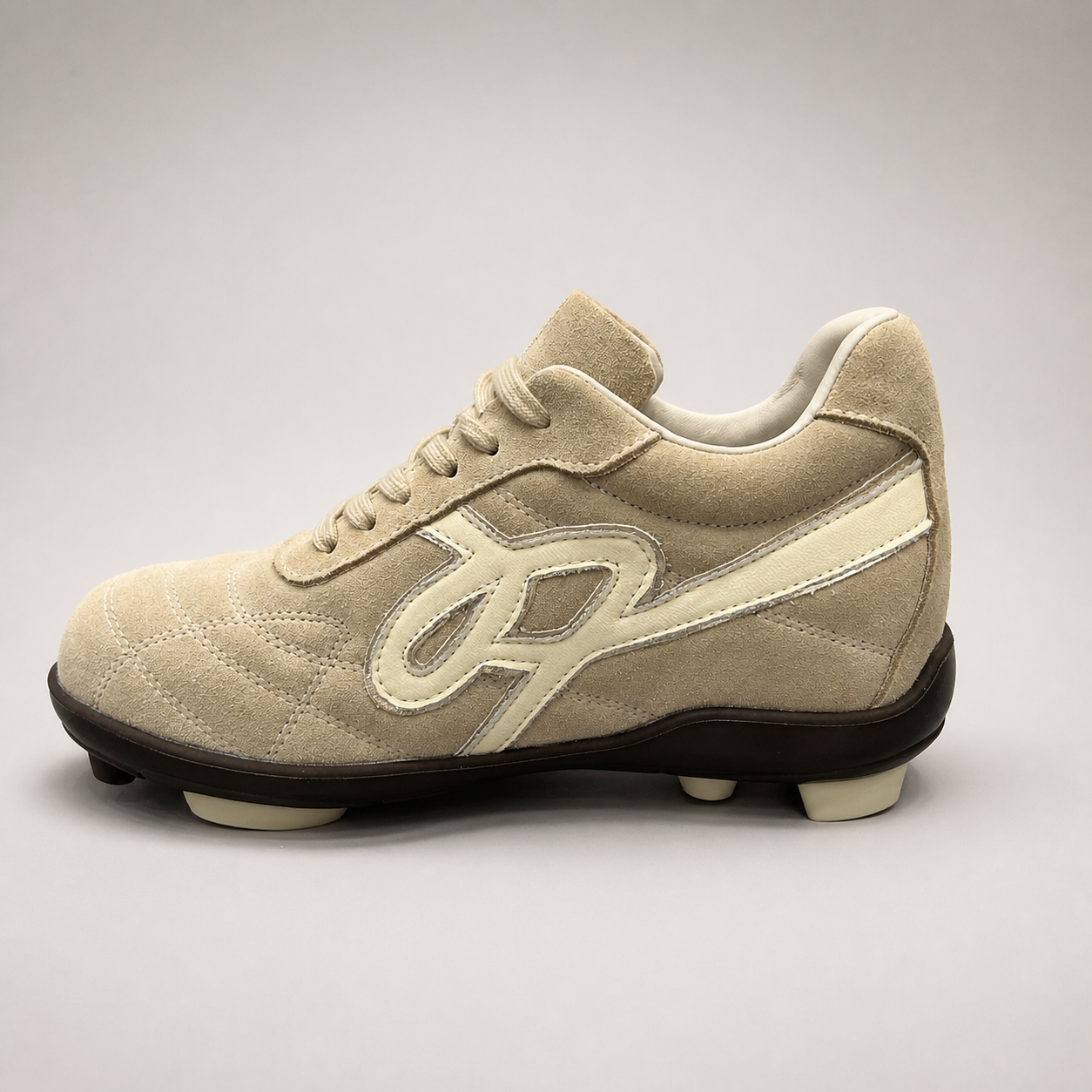 Beige soccer shoe side profile showing a lace-up upper and molded outsole studs