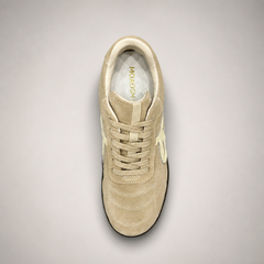 Beige soccer shoe top view showing a lace-up upper and molded outsole studs