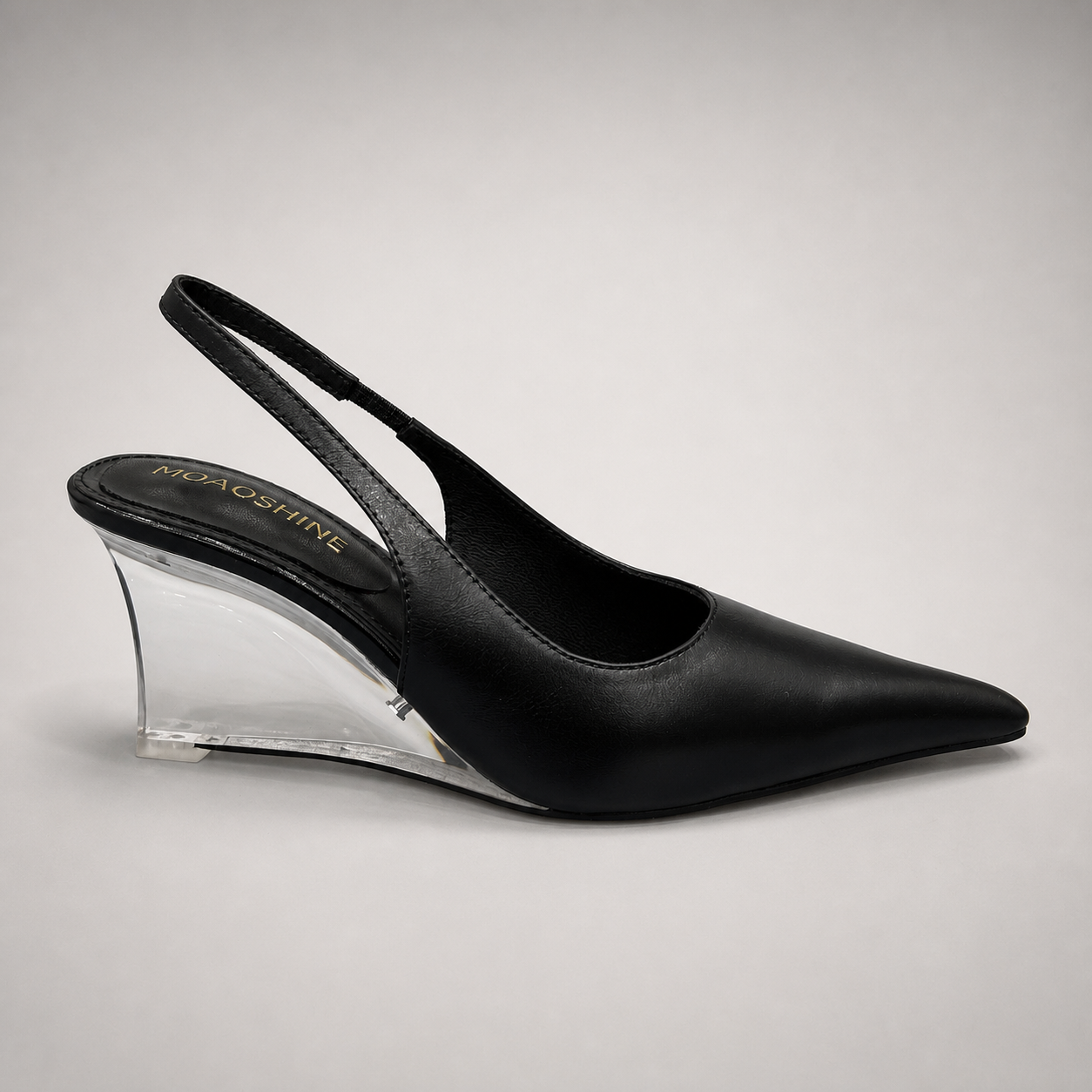 Black wedge slingback pump side profile showing a pointed toe, slingback strap, and clear wedge heel
