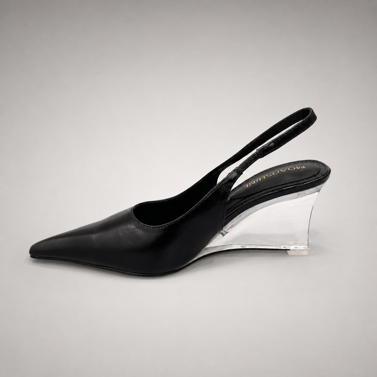 Black wedge slingback pump opposite side profile showing a pointed toe, slingback strap, and clear wedge heel