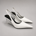 White wedge slingback pump pair three-quarter view showing a pointed toe, slingback strap, and clear wedge heel