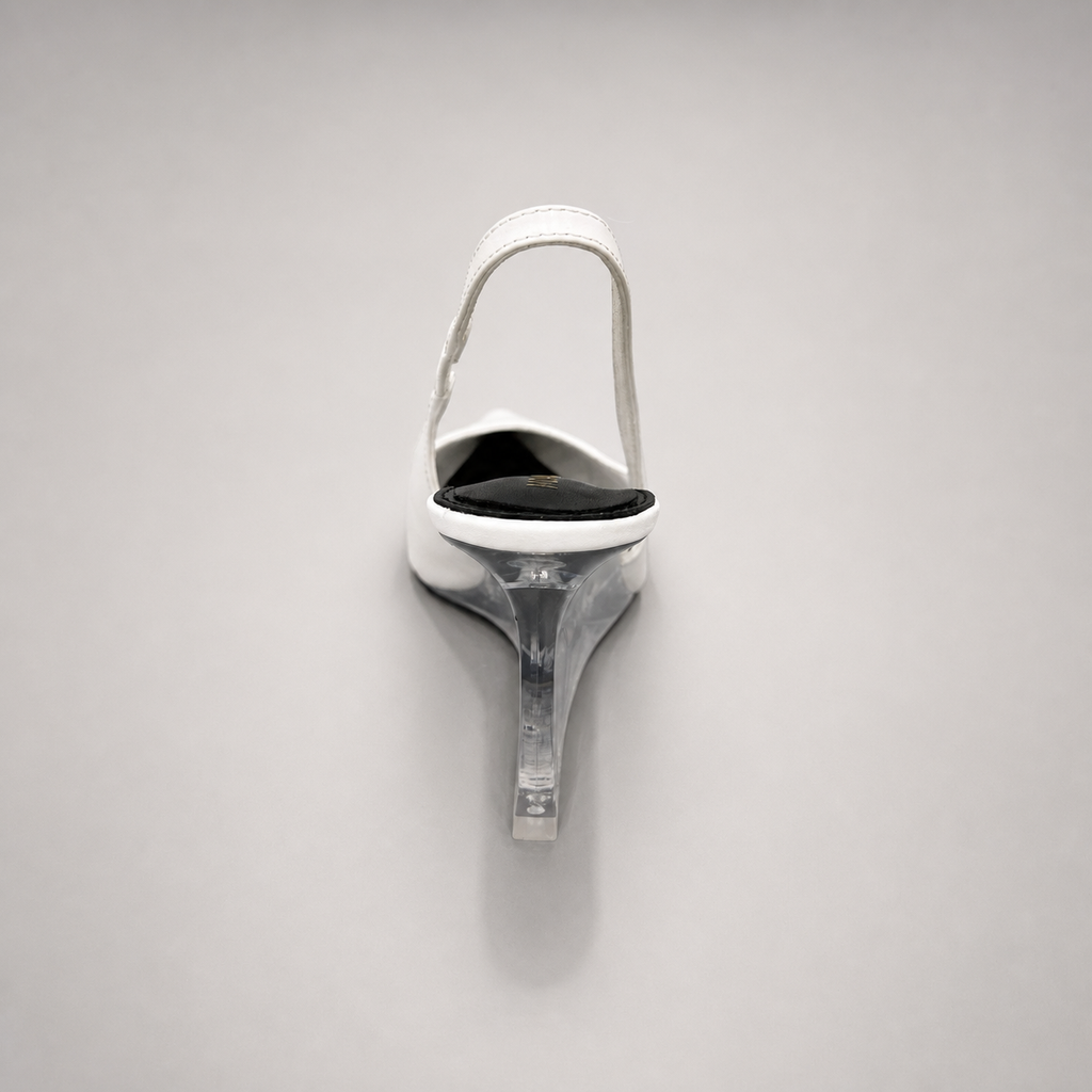 White wedge slingback pump rear view showing a pointed toe, slingback strap, and clear wedge heel