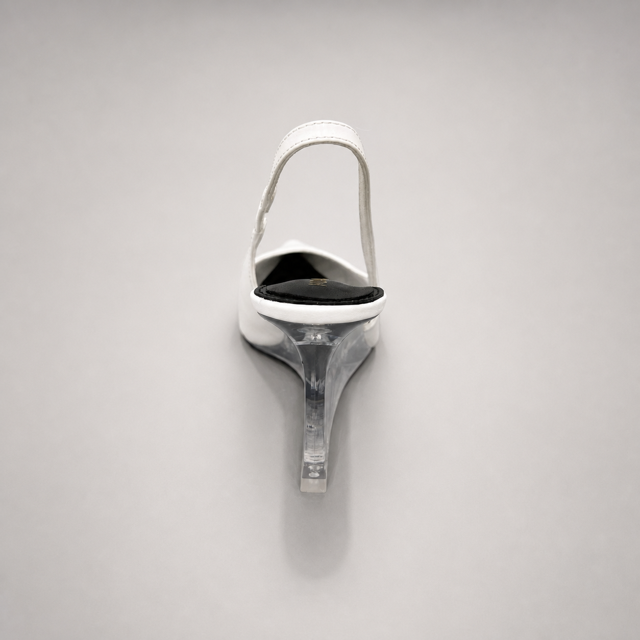 White wedge slingback pump rear view showing a pointed toe, slingback strap, and clear wedge heel