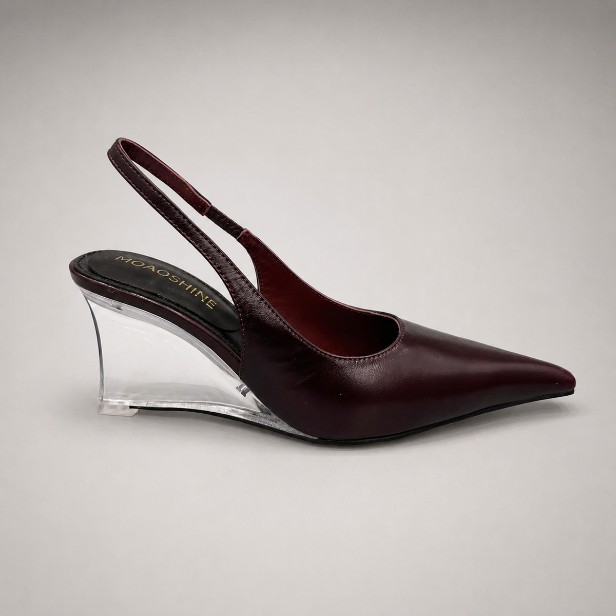 Burgundy wedge slingback pump side profile showing a pointed toe, slingback strap, and clear wedge heel
