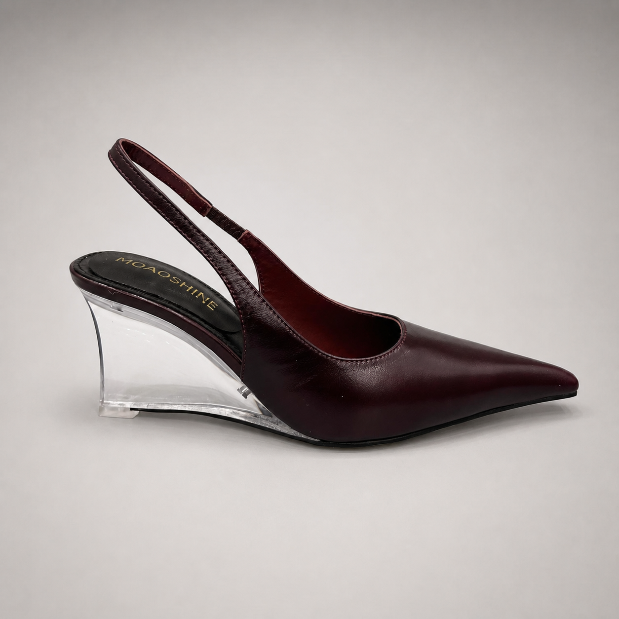 Burgundy wedge slingback pump side profile showing a pointed toe, slingback strap, and clear wedge heel