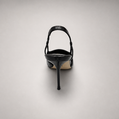 Black slingback pump rear view showing a pointed toe, slingback strap, and metal toe cap