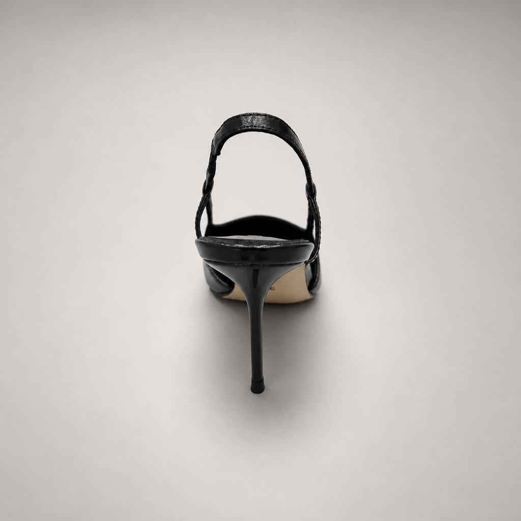 Black slingback pump rear view showing a pointed toe, slingback strap, and metal toe cap
