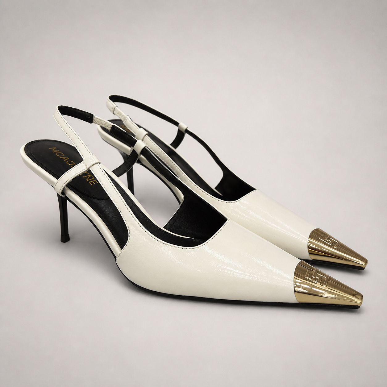 White slingback pump pair three-quarter view showing a pointed toe, slingback strap, and metal toe cap