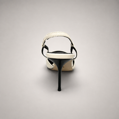White slingback pump rear view showing a pointed toe, slingback strap, and metal toe cap