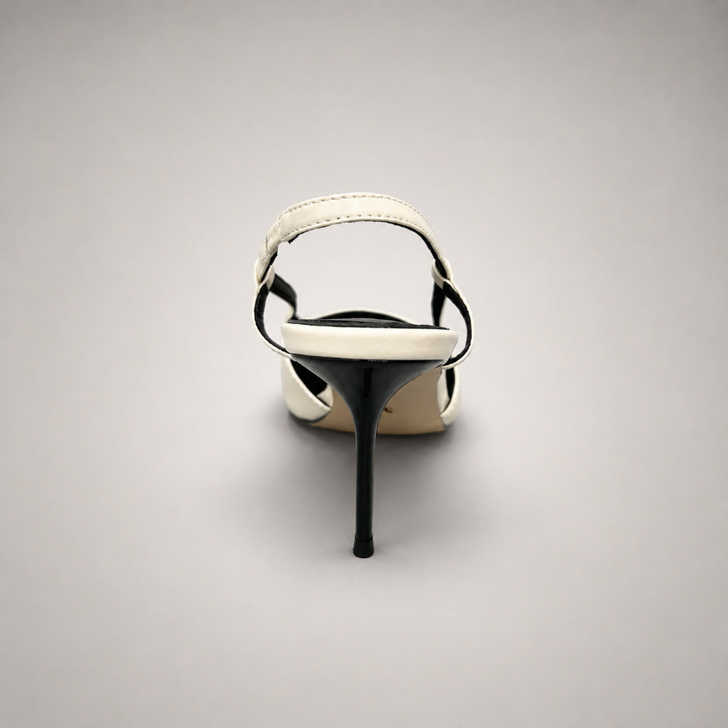 White slingback pump rear view showing a pointed toe, slingback strap, and metal toe cap