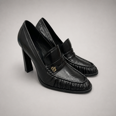 Black high-heeled loafer pair three-quarter view showing a loafer-inspired vamp and block heel
